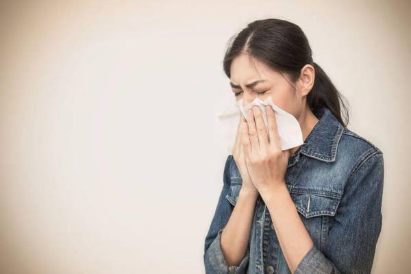 woman with the flu sneezing