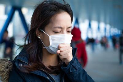 woman coughing wearing mask