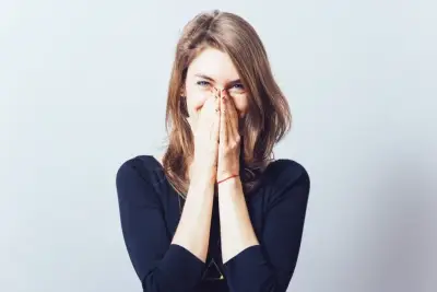 woman holding her face while laughing