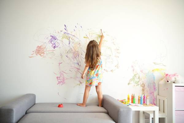 kid painting on wall