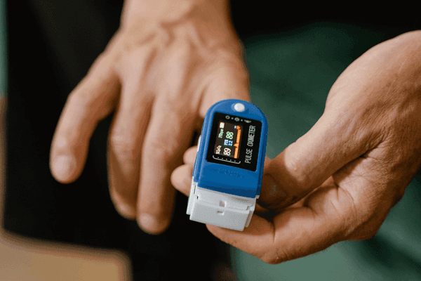 Clipping a pulse oximeter onto the finger.